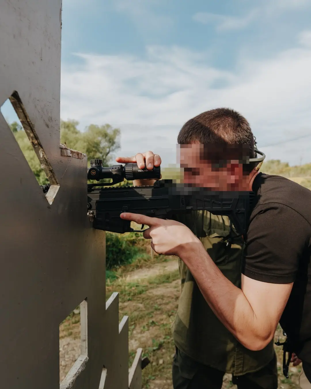 Participant fires a carbine from behind a barricade