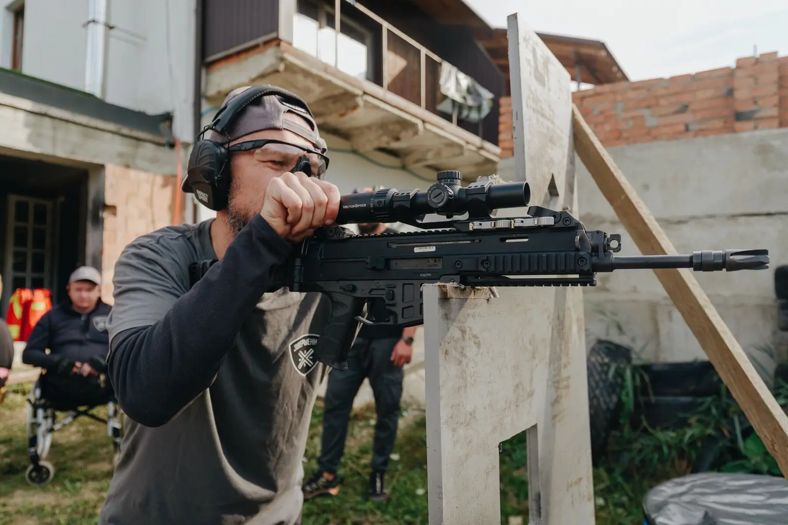 Teilnehmer zielt mit einem Karabiner mit Optik aus der Deckung