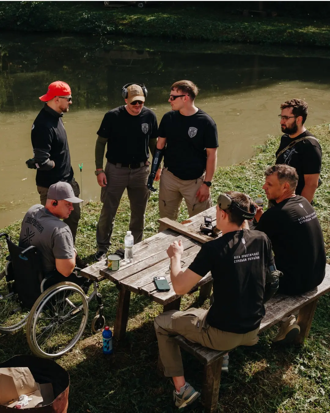 Participants talk at a table by the water
