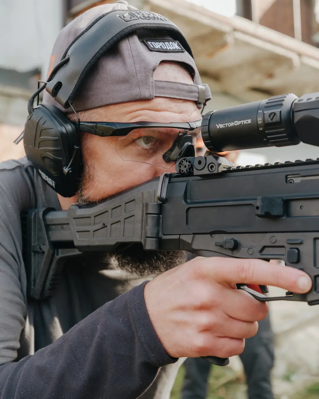 Participant aims through a rifle optic