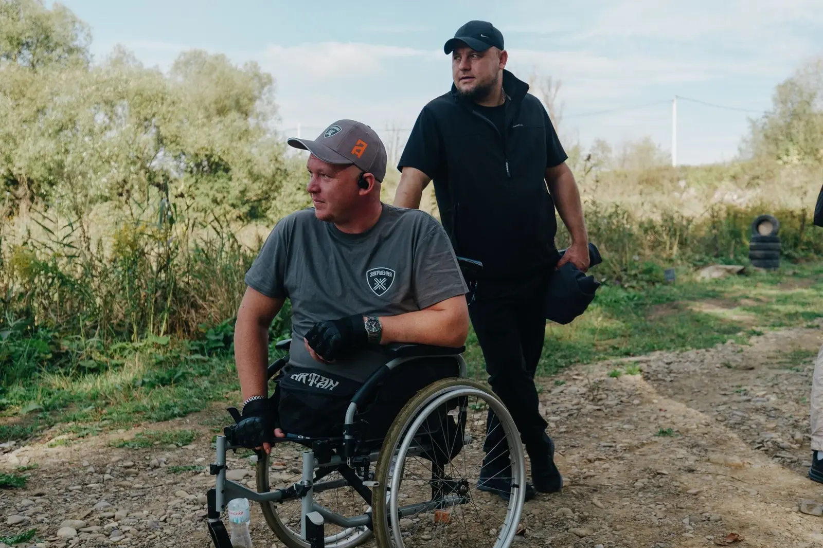 Veteran im Rollstuhl fährt mit einem Teamkollegen zur nächsten Station